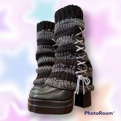 a pair of black and gray boots with laces on the top, sitting on a purple background