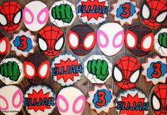 decorated cookies are arranged in the shape of spiderman's face and name on them