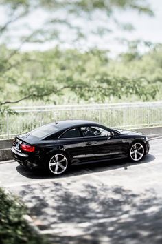 a black sports car driving down the road