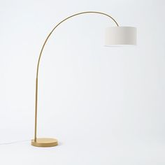 a floor lamp with a white shade on the base and a light bulb attached to it