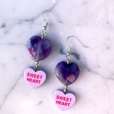 Gemstones are genuine amethyst metal is stainless steel earring wires are hypoallergenic Purple Metal Drop Earrings, Purple Dangle Heart Earrings For Pierced Ears, Purple Double Heart Jewelry Gift, Purple Double Heart Jewelry For Gifts, Trendy Dangle Crystal Earrings For Gifts, Trendy Crystal Dangle Earrings Gift, Trendy Dangle Crystal Earrings, Purple Heart Sterling Silver Jewelry, Purple Sterling Silver Heart Jewelry