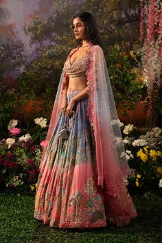 A captivating blend of hues and textures along with nalki crystals and lavish hand embroidery crafts this mesmerizing Iris lehenga set. The playful hues create that joyful vibe for the celebrations and as paired up with a glamorous cowl neck blouse the ensemble exudes a playful glam. With the complimentary net dupatta prepare to dazzle and make an unforgettable statement. The blouse features a cowl neckline embellished with sequins, beads, and nalki crystals. The blouse comes with attached rhinestone studded straps along with an attached hook on the backside. The pleated lehenga skirt, adorned with hand-embroidered nalki crystals, sequins, and beads, is a stunning blend of blue and pink hues. Butterfly Net dupatta immersed in the blend of pink and white hues with floral embroidery and cutw Luxury Festival Lehenga With Zari Work, Luxury Embellished Lehenga For Spring, Luxury Multicolor Embroidered Gown For Festivals, Luxury Spring Embellished Lehenga, Luxury Lehenga With Zari Work For Festivals, Luxury Multicolor Gown With Cutdana, Luxury Lavender Designer Lehenga, Luxury Semi-stitched Lehenga For Festival, Luxury Lehenga With Resham Embroidery For Spring