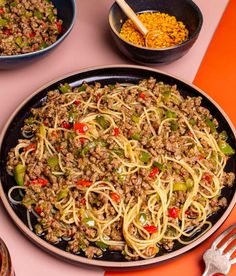 a pan filled with noodles and vegetables on top of a table