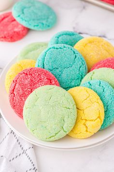 a white plate topped with colorful cookies on top of a table