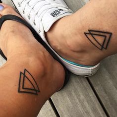 two people with tattoos on their legs and one has a small triangle in the middle