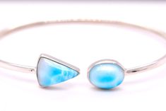 This gorgeous Dominican larimar bracelet will become your go to choice for accessorizing. This one is made with natural blue Dominican larimar set in sterling silver. These bracelets are flexible and can be twisted to slip on easily, at the same time they are durable enough for daily wear. They will fit small, medium or large wrists. Gemstones- Dominican Larimar Material : Sterling Silver See other items from my store here https://www.etsy.com/shop/GalantaJewels?ref=hdr_shop_menu Packaging : All products purchased from us come in a gift box. If you need to include a message, kindly leave us a note when purchasing.  Care Recommendations:  When not in use, keep earrings enclosed in a box or pouch to minimize exposure to moisture in air. Do not spray aromatics directly onto product. Minimize Larimar Bracelet Jewelry Gift, Adjustable Blue Larimar Jewelry, Elegant Turquoise Larimar Bracelets, Handmade Adjustable Larimar Bracelets, Turquoise Larimar Natural Stone Bracelets, Turquoise Larimar Bracelet, Blue Larimar Hypoallergenic Jewelry, Turquoise Larimar Bracelets For Gifts, Turquoise Larimar Bracelets As A Gift