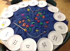 paper plates with letters and numbers arranged in the shape of a circle on top of a table