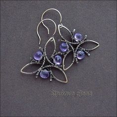 the earrings are made out of wire and have purple glass beads hanging from each ear