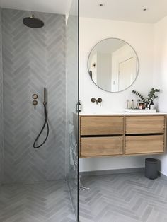 a bathroom with a shower, sink and mirror