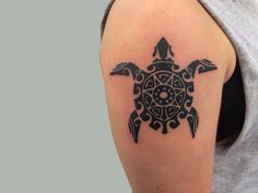 a woman's arm with a tattoo on it that has a turtle and geometric design