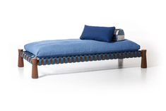 a blue chaise lounge with pillows on it's back and legs in front of a white background