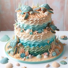 a multi layer cake decorated with sea shells and sea turtle figurines on a table