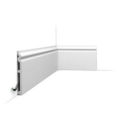 the corner of a white wall with an electrical outlet on it's side and one section missing