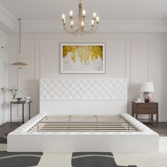 a white bed sitting under a chandelier in a bedroom