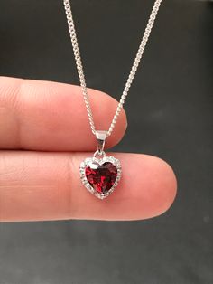 "Small Sterling Silver Garnet CZ Heart Necklace Garnet is the birthstone for January, this makes a great gift for those loved ones born January. Metal: All components are made from solid .925 Sterling Silver Stone: Cubic Zirconia Center Stone size: 7mm Center Stone Carat Weight: 1.6ct Measurement: pendant height is 14mm (0.55\") including bail and 10mm (0.39\") wide Choose Chain Length At Checkout Please feel free to Convo me with any questions before purchasing. Please view policy before purcha Garnet Snowflake Necklace, Heart-shaped Cubic Zirconia Jewelry For Valentine's Day, Cubic Zirconia Necklace For May Birthstone Gift, Heart-shaped Gemstone Heart Necklace For Weddings, Heart-shaped Gemstone Necklace For Wedding, Heart-shaped Cubic Zirconia Birthstone Necklace, Heart-shaped Birthstone Necklace In Cubic Zirconia, Valentine's Day Birthstone Necklace For Birthday Gift, Cubic Zirconia Heart Necklace With Gemstone For Valentine's Day