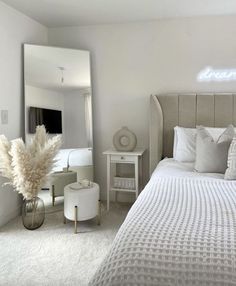 a bedroom with a bed, mirror and stools