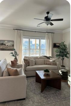 a living room filled with furniture and a ceiling fan