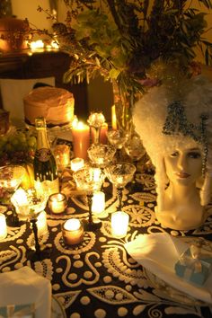 a table topped with candles and a mannequin head