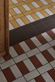 an open door on a tiled floor with brown and white tiles