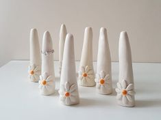 six white vases with flowers and bows on them