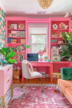 a living room with pink walls and lots of green plants in the window sill