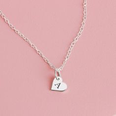 Tell your special someone how much they mean to you with this personalized sideways heart necklace. This sweet and dainty necklace features a tiny sideways heart charm that can be customized with a single initial or symbol of your choice. The necklace is crafted from sterling silver and hangs on a delicate chain. It's the perfect way to show your loved one how much they mean to you! MGJ's Engraved Disc Necklaces are custom-designed and expertly deep-engraved for lasting quality. This means that Sterling Silver Initial Pendant Charm Necklace For Mom, Dainty Silver Heart Pendant Initial Necklace, Silver Heart Pendant Initial Necklace, Silver Heart Pendant Initial Necklace In Sterling Silver, Silver Sterling Silver Heart Pendant Initial Necklace, Dainty Sterling Silver Name Necklace With Charms, Minimalist Sterling Silver Heart Charm Necklace, Dainty Silver Initial Necklace For Valentine's Day, Dainty Sterling Silver Charm Necklaces For Valentine's Day