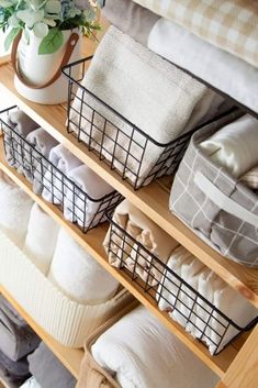 the shelves are filled with folded towels and other linens, along with a potted plant