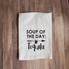 a white tea towel with the words soup of the day tequila on it and an arrow