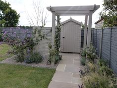 an outdoor garden with a stone path leading to a shed