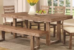 a dining room table with two benches in front of it and a vase full of flowers on the table