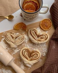 some oranges are on a cutting board next to a cup of coffee