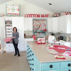 a woman standing in a kitchen with lots of crafting supplies on the counter top