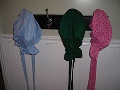 three hats hanging on the wall next to each other with ties in front of them