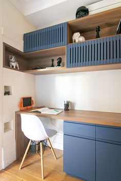 a desk and chair in a room with wooden flooring, built - in bookshelves