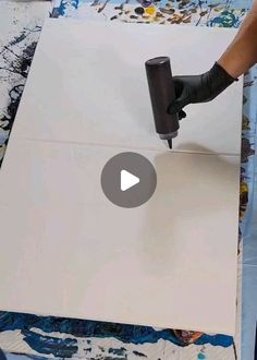 someone is using a drill to paint on a piece of white paper with black ink