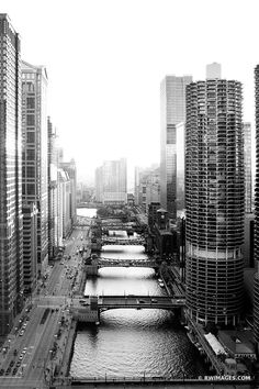 an aerial view of a city with tall buildings and river in the foreground, along with other large skyscrapers