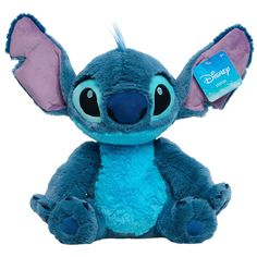 a blue stuffed animal with an ear tag on it's head and ears, sitting in front of a white background