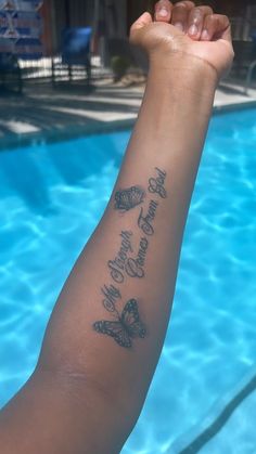 a person with a tattoo on their arm next to a swimming pool that says, you are the only one