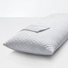 a pillow with a white cover is laying on the floor