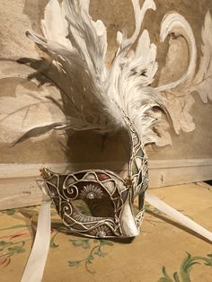 "This mask with feathers belongs to our collection of masks \"Lady Plumes\". The fetaher masks are the most elegant, refine and stunning masks of our collections. This mask is a traditional and original papier-mache Venetian mask, handmade and decorated in our Atelier in Venice using velvet , fabrics, Swarovski, feathers, different trimming. It is perfect for any masquerade party, Halloween costume, pro or event in Venice or elsewhere during Carnival. This mask can be gently bent to form to your Artistic Masks For Carnival Costume Party, Artistic Masks And Prosthetics For Carnival Masquerade, Artistic Masks For Costume Party And Carnival, Artistic Masquerade Mask For Carnival Costume, Artistic Masks And Prosthetics For Masquerade Carnival, Artistic Masks And Prosthetics For Carnival Costume, Venetian Masks For Carnival Costume, Artistic Costume Masks And Prosthetics For Carnival, Elegant Masks And Prosthetics For Mardi Gras Carnival