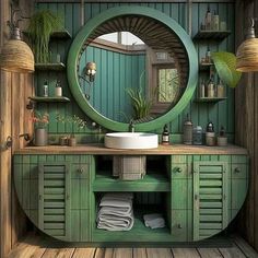 a bathroom with green cabinets and a round mirror