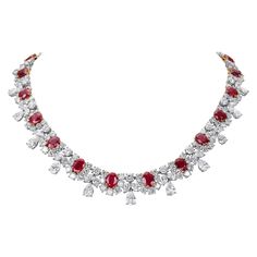 This spectacular necklace is built around 22 oval-cut Burma rubies ranging in size from approximately 2.50 carats to 0.95 carats totalling approximately 38 carats. The rubies exhibit a rich vivid red hue and excellent crystal transparency. Each ruby is accentuated by a diamond horseshoe comprised of 189 round brilliant diamonds weighing approximately 29.70 carats. There are 22 diamond drop sections containing a total of 22 pear shape, 44 marquise, and 22 round brilliant diamonds weighing approxi Luxury Fusion Style Ruby Necklace, Chinese Pendant, Ruby Diamond Necklace, Ruby And Diamond Necklace, Diamond Tiara, Diamond Jewelry Designs, Ruby Necklace, Cluster Necklace, Mom Jewelry