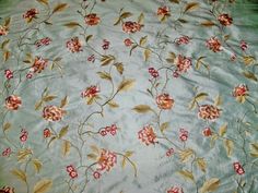 an image of a flowered fabric with flowers on the side and green leaves in the middle