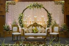 a decorated stage with white couches and flowers