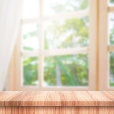 an empty wooden table in front of a window