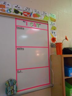 a white board with writing on it next to a book shelf filled with books and other items