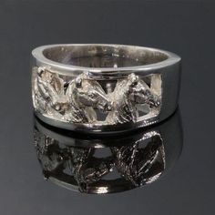 a silver ring with horses on it