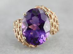 A deep eggplant purple amethyst glitters with light and flash at the center of this asymmetrical, Mod style cocktail ring! Light and airy for all of its substantial size, this vintage piece is sure to make an impression! Metal: 10K Yellow Gold Gem: Amethyst 7.33 Carats Gem Measurements: 15.8 x 11.7 mm, Oval Ring Size: 6.75 Marks: "10K" Stamped on the inside band Luxury Purple Rings For Party, Luxury Purple Party Rings, Elegant Amethyst Rings For Parties, Elegant Amethyst Party Rings, Purple Gemstone Rings For Party, Purple Gemstone Party Rings, Purple Oval Rings For Party, Purple Oval Party Rings, Beautiful Rings Vintage