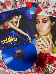 a blue vinyl record sitting on top of a table next to red roses and cards