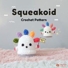 two small crocheted animals are on top of a pink blanket with the words squeakoid written above them